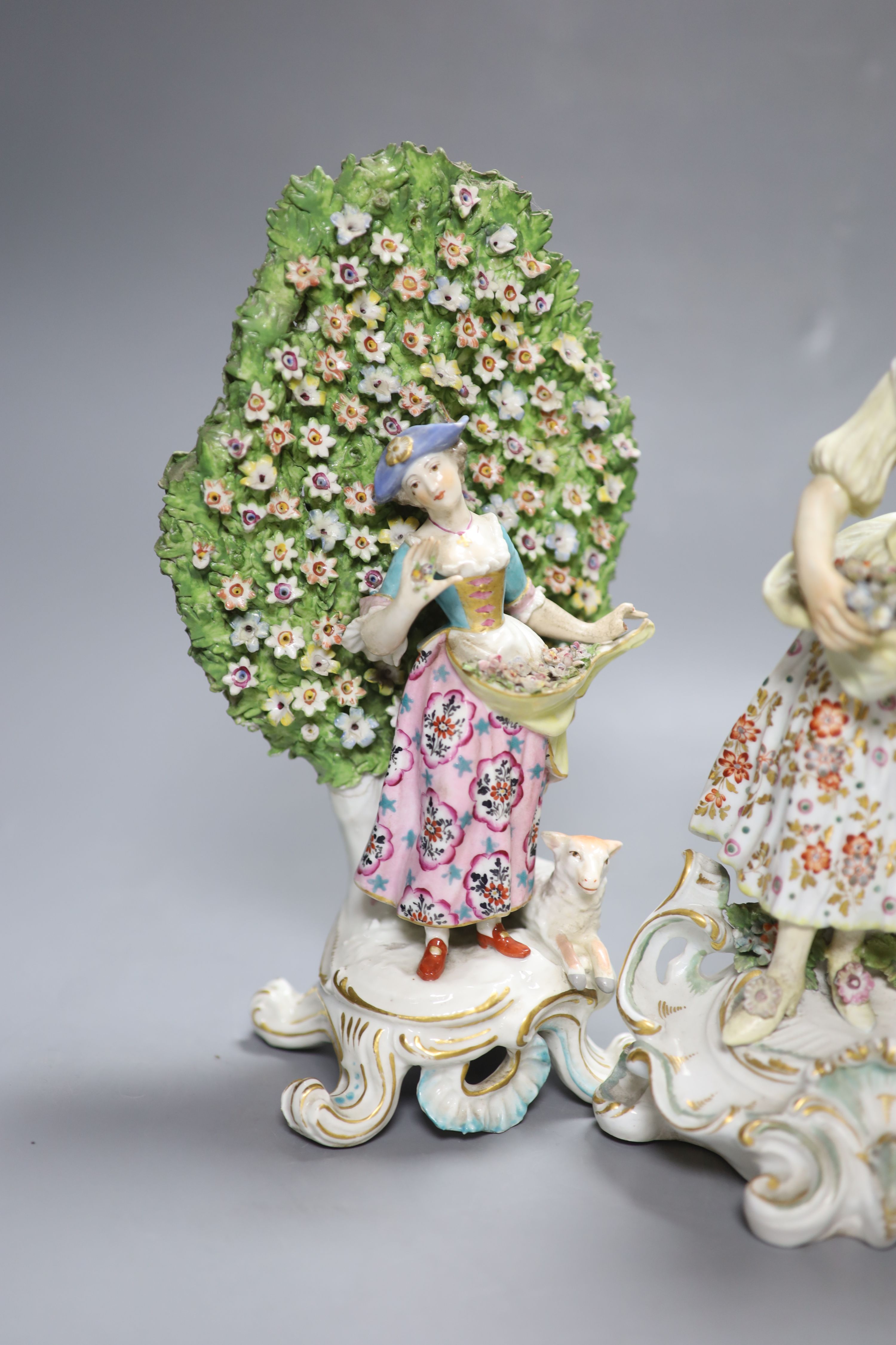 An 18th century Derby figure of a flower seller and a pair of French porcelain bocage groups, tallest 27cm